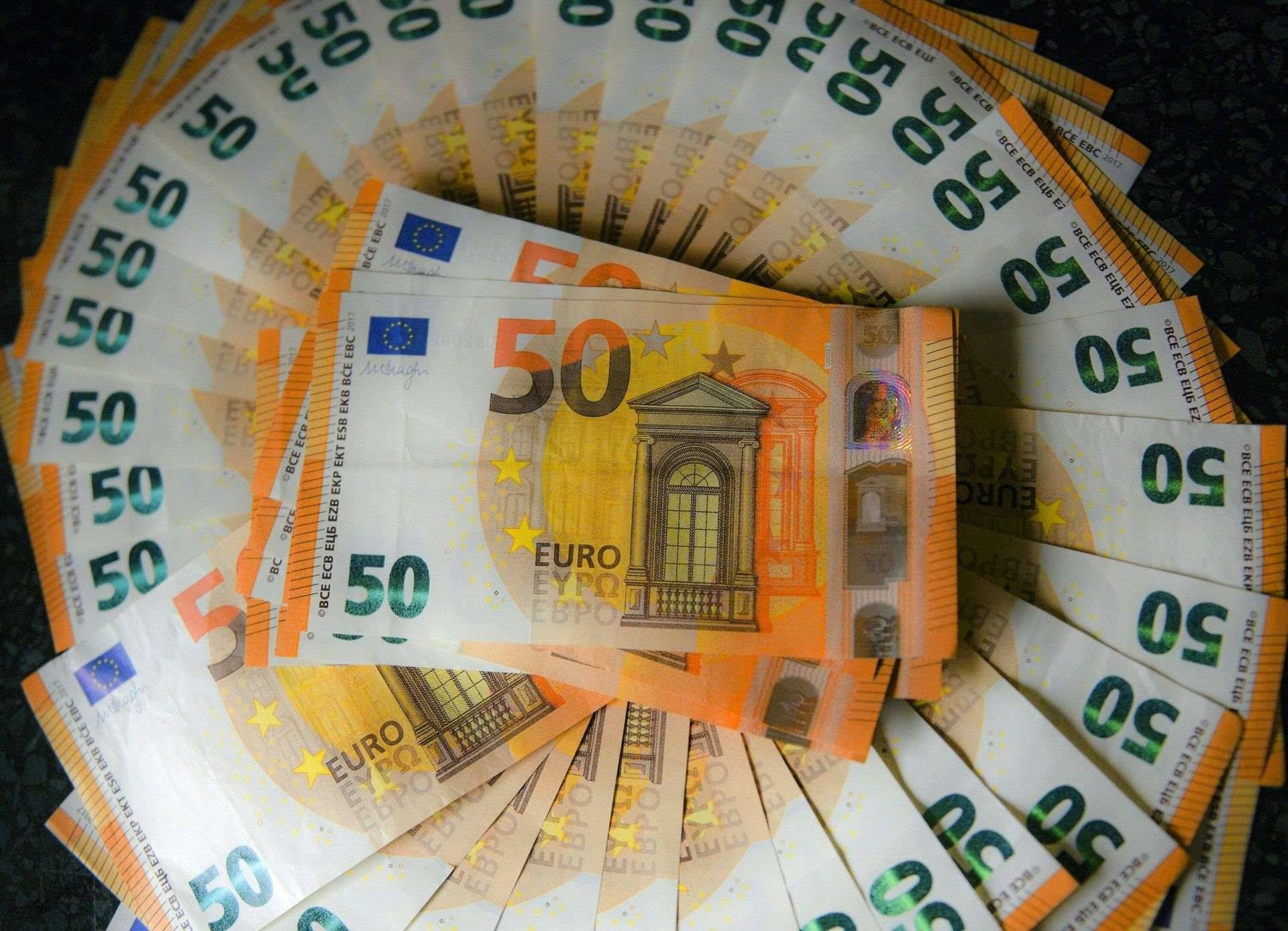 A picture taken on 29 August, 2017 in Arras, northern France, shows fifty euro banknotes on table. The new 50 euro banknote was introduced in the 19 countries of the euro area on April 4, 2017. / AFP PHOTO / DENIS CHARLET