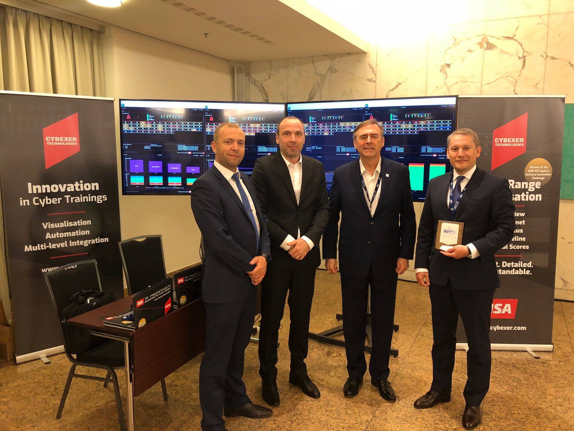 CybExer Technologies’i meeskond täna Berliinis NITEC 18 konverentsil pärast auhinnatseremooniat - küberohtude valdkonna juhi Klaid Mägi (vasakult), juhatuse liige Janek Gridin ja juhatuse esimees Andrus Kivisaar, kelle kõrval seisab NATO NCI peadirektor Kevin J. Scheid.