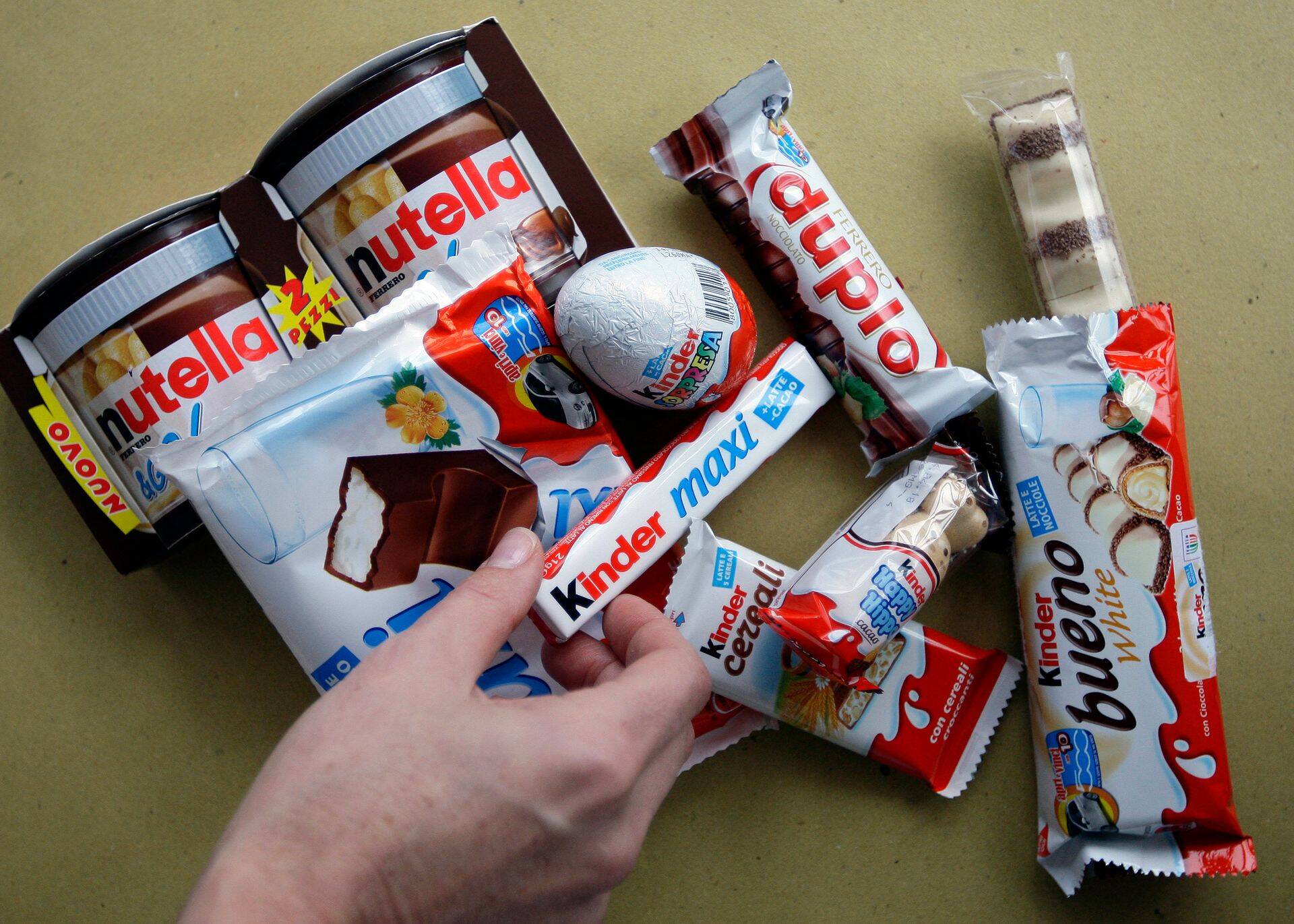 A woman takes a Kinder Ferrero chocolate in Milan November 20, 2009. Cadbury suitors Ferrero and Hershey would likely break the UK confectioner up into separate businesses if a mooted bid for the company succeeds, an Italian newspaper reported. Italian chocolate maker Ferrero and U.S.-based Hershey said on Wednesday they were reviewing a possible offer for Cadbury, which is the subject of a hostile 9.9 billion pound ($16.5 billion) bid by U.S. food group Kraft. Unlisted Ferrero is mainly interested in Cadbury's gum and candy division, a unit worth about 5 billion euros ($7.4 billion), business daily Il Sole 24 Ore said on Friday.              REUTERS/Stefano Rellandini (ITALY BUSINESS FOOD)