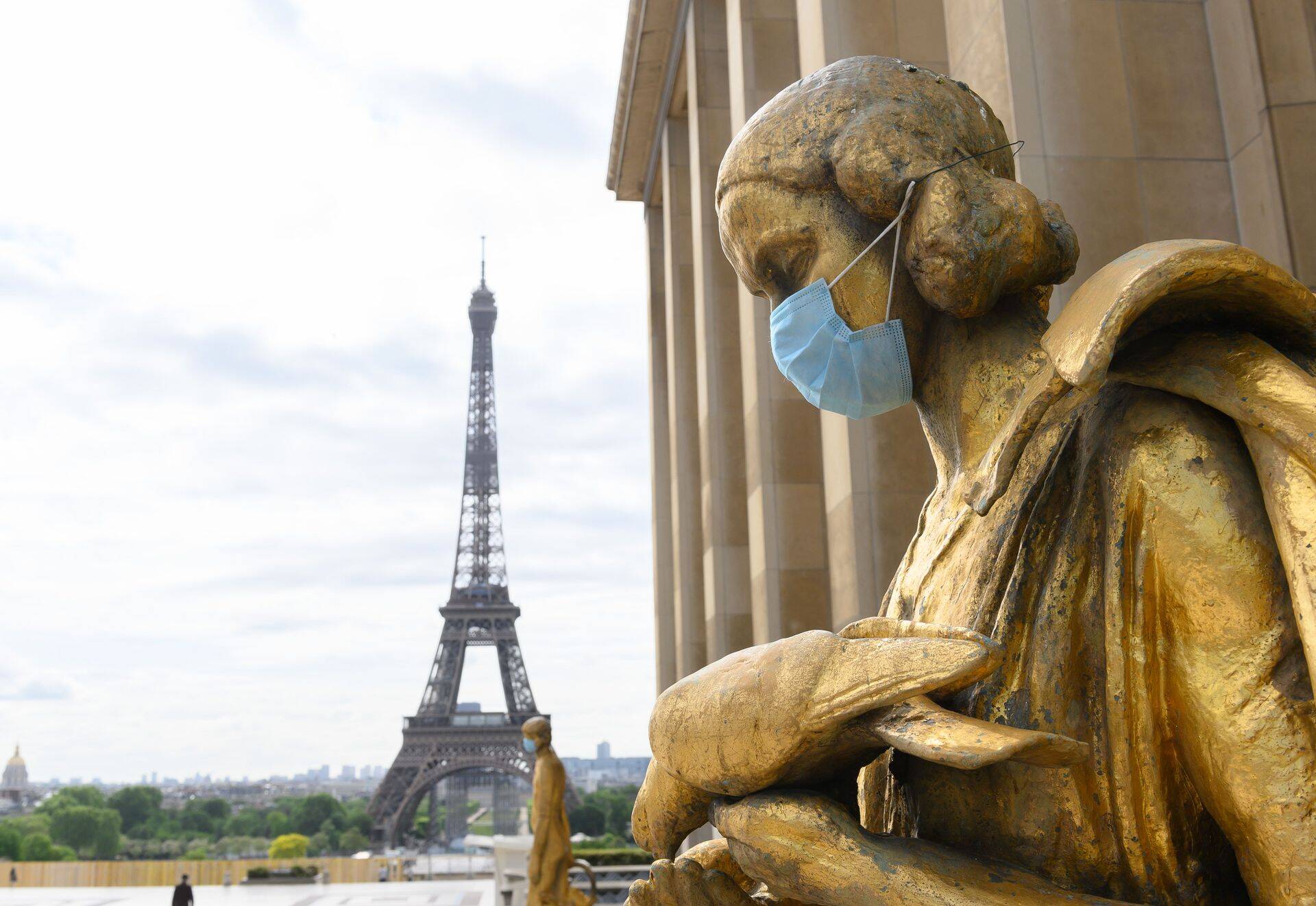Pronksist kuju maski kandmas, Eiffeli torn taustal.
