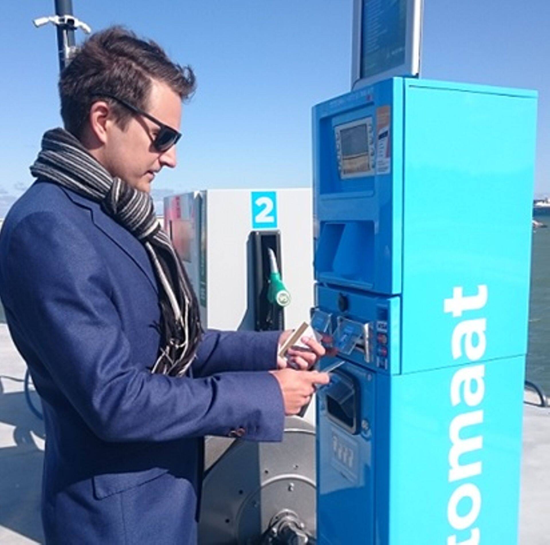 Omniva infoäri juht Sander Aasna näidistankimist sooritamas ning esimest e-kviitungit saamas.