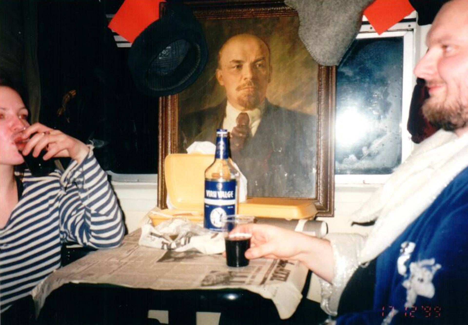 Четыре вагона, полные людей с красными флагами и портретами Ленина, кто в форме Советской армии, кто в шинелях и буденовках, кто в тельняшках, кто в пионерских галстуках.