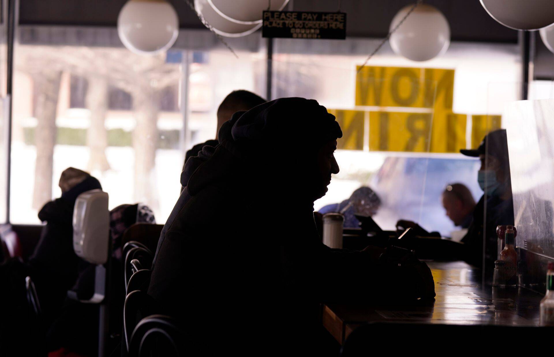 Külmetavad kliendid istuvad pimedas restoranis. Richardson, Texas