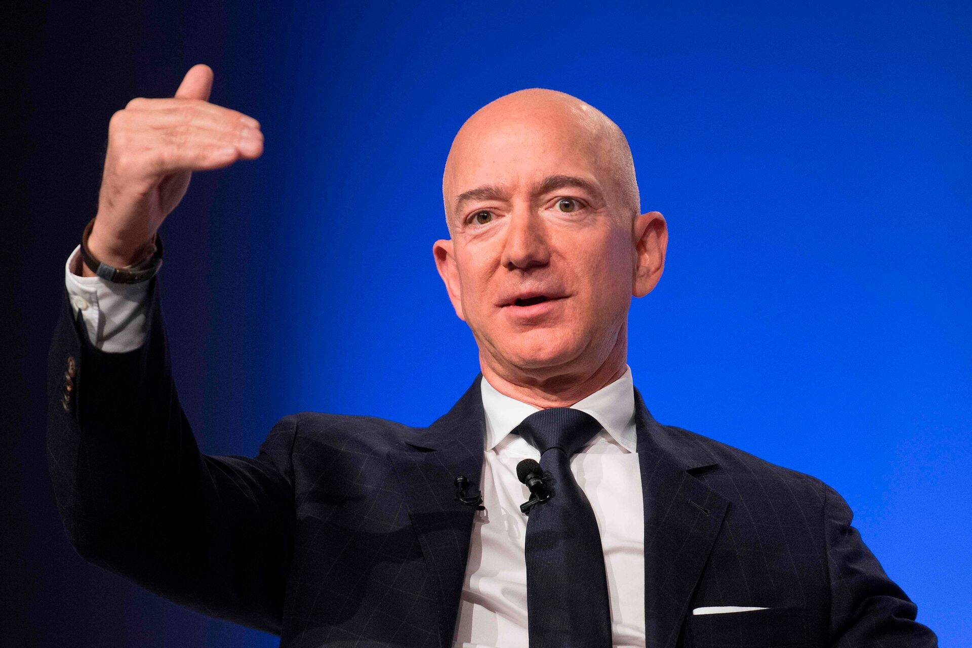 (FILES) In this file photo taken on September 19, 2018 Amazon and Blue Origin founder Jeff Bezos provides the keynote address at the Air Force Association's Annual Air, Space & Cyber Conference in Oxen Hill, Maryland. - Online retail giant Amazon announced on October 2, 2018 it would raise its starting wage for US workers to $15 an hour, amid long-standing criticism of low pay, and advocate for a higher minimum wage nationwide.The pay raise will apply to 250,000 employees, starting November 1, and to the more than 100,000 seasonal workers the company expects to hire for the holiday shopping season. (Photo by Jim WATSON / AFP)