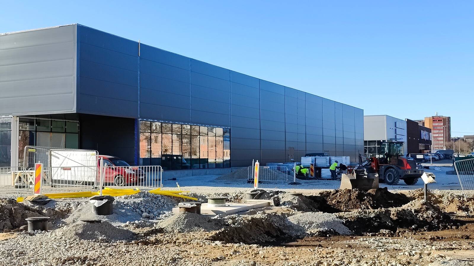Сразу за новостройкой Coop виднееся Maxima примерно такого же размера.
