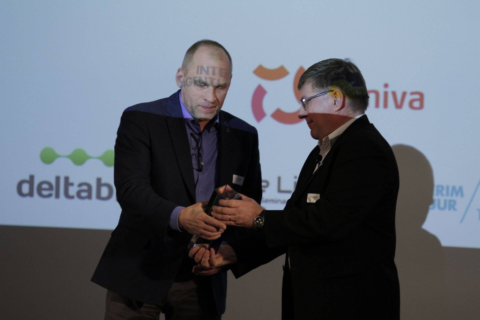 PROLOGi juhatuse esimees Tõnis Hintsov annab üle tänavuse Tarneahelategija tiitli Post11 operatsioonide juhile Gunnar Arule (vasakul).