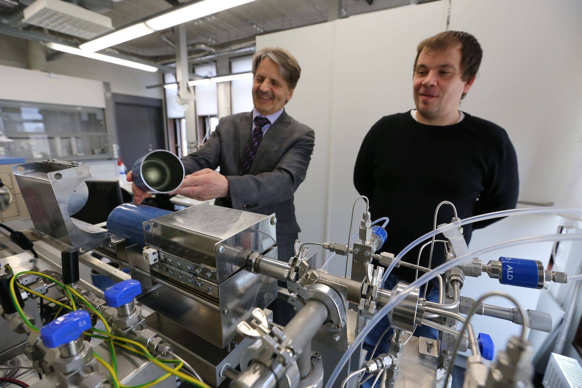 Tartu Ülikooli füüsika instituudi materjaliteaduse osakonna juhataja Väino Sammelselg (vasakul) näitab tükki gaasiballoonist, mille sisepind on kaetud nanomaterjaliga. Tema kõrval seisab kiletehnoloogia insener Lauri Aarik.
