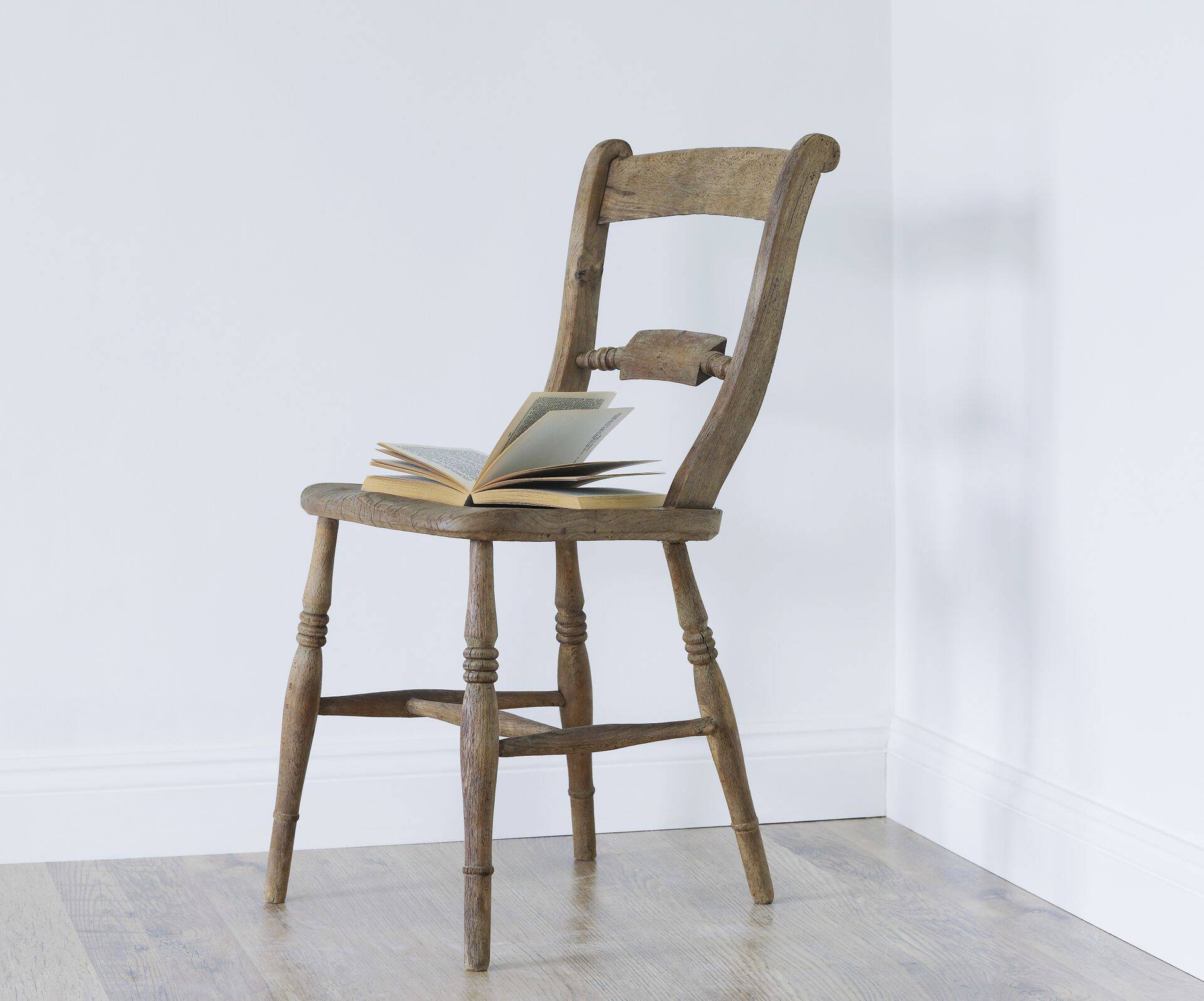 Open book on chair in empty room corner
