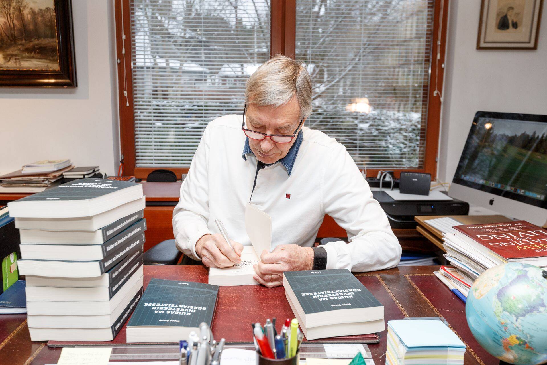 Seppo Saario oma raamatutesse autogramme kirjutamas.