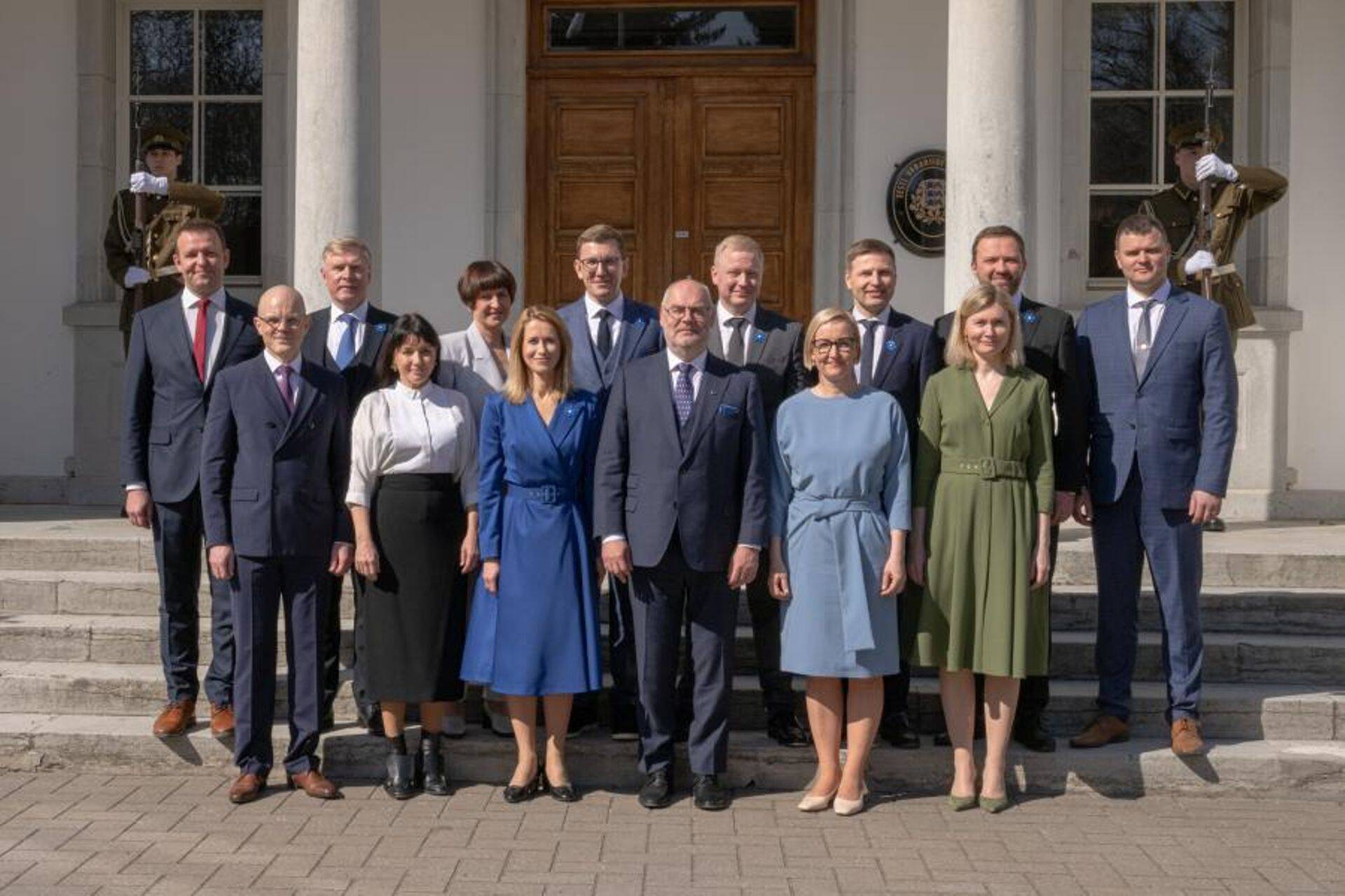 Новое правительство позирует с президентом Аларом Карисом.