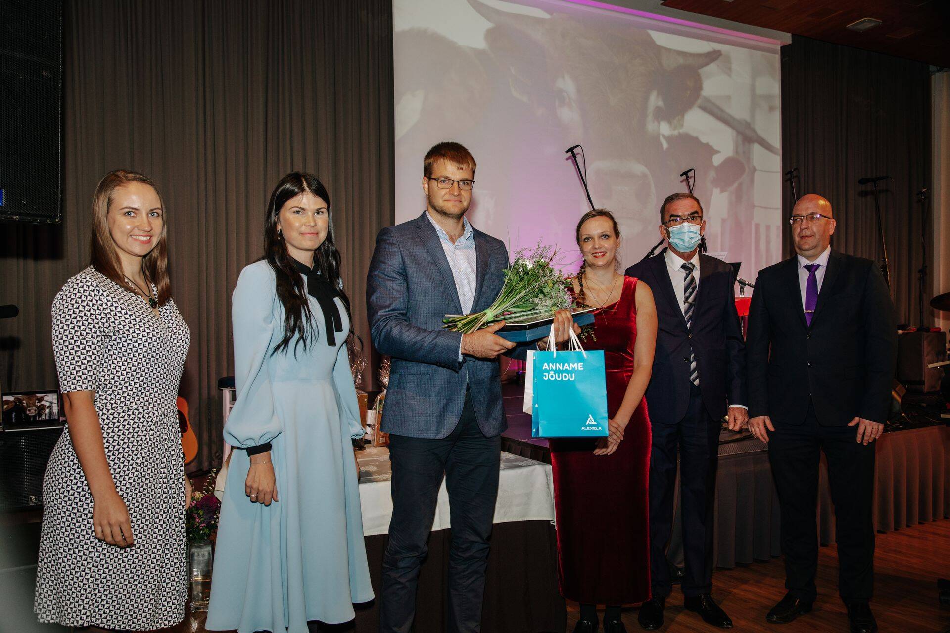 Parima talu tiitli võitja Raudepere OÜ juht (keskel) tiitlit vastu võtmas.