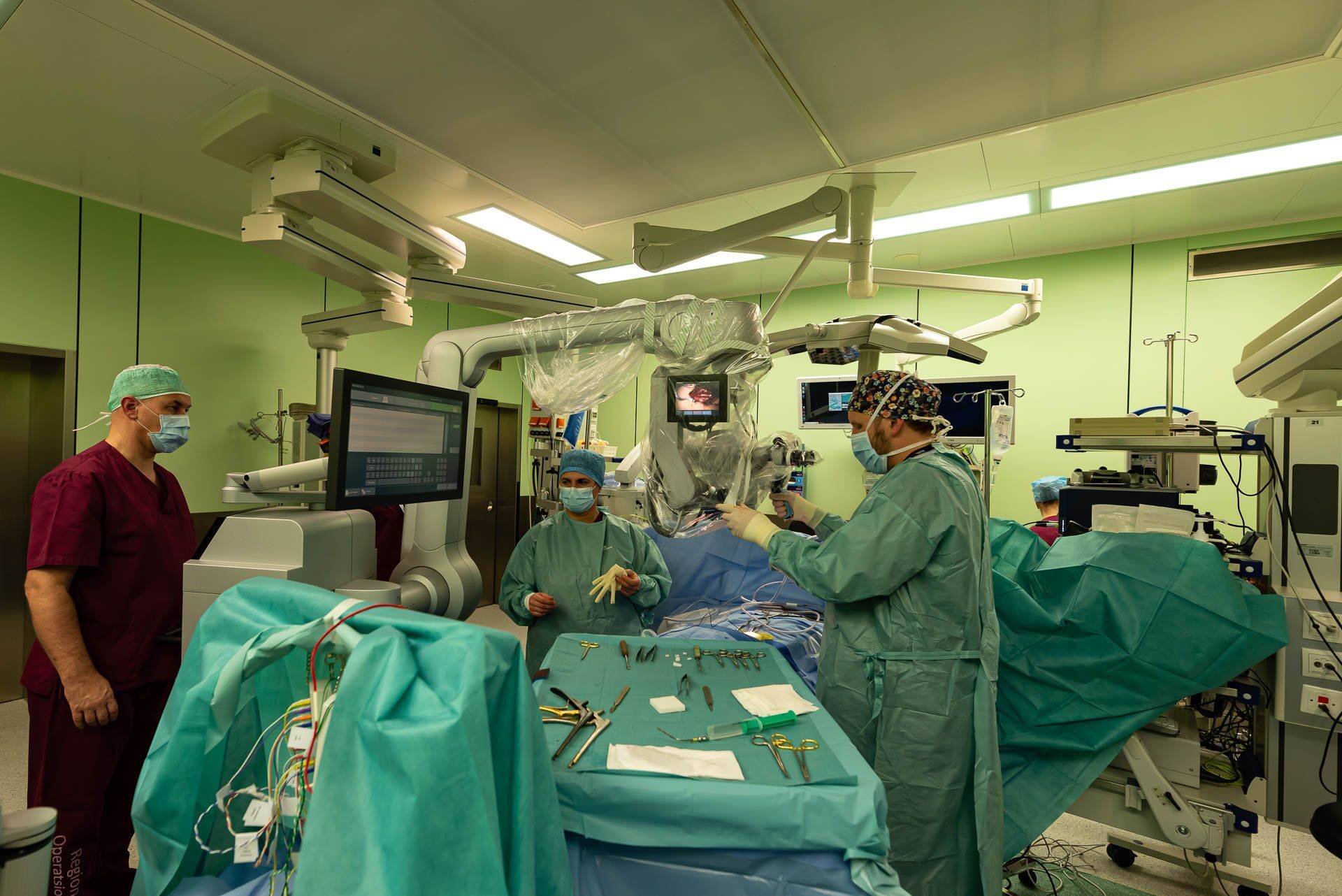 Vasakult neurokirurgid Tarmo Areda, Sevgi Sarikaya-Seiwert ja Andres Asser operatsioonisaalis.