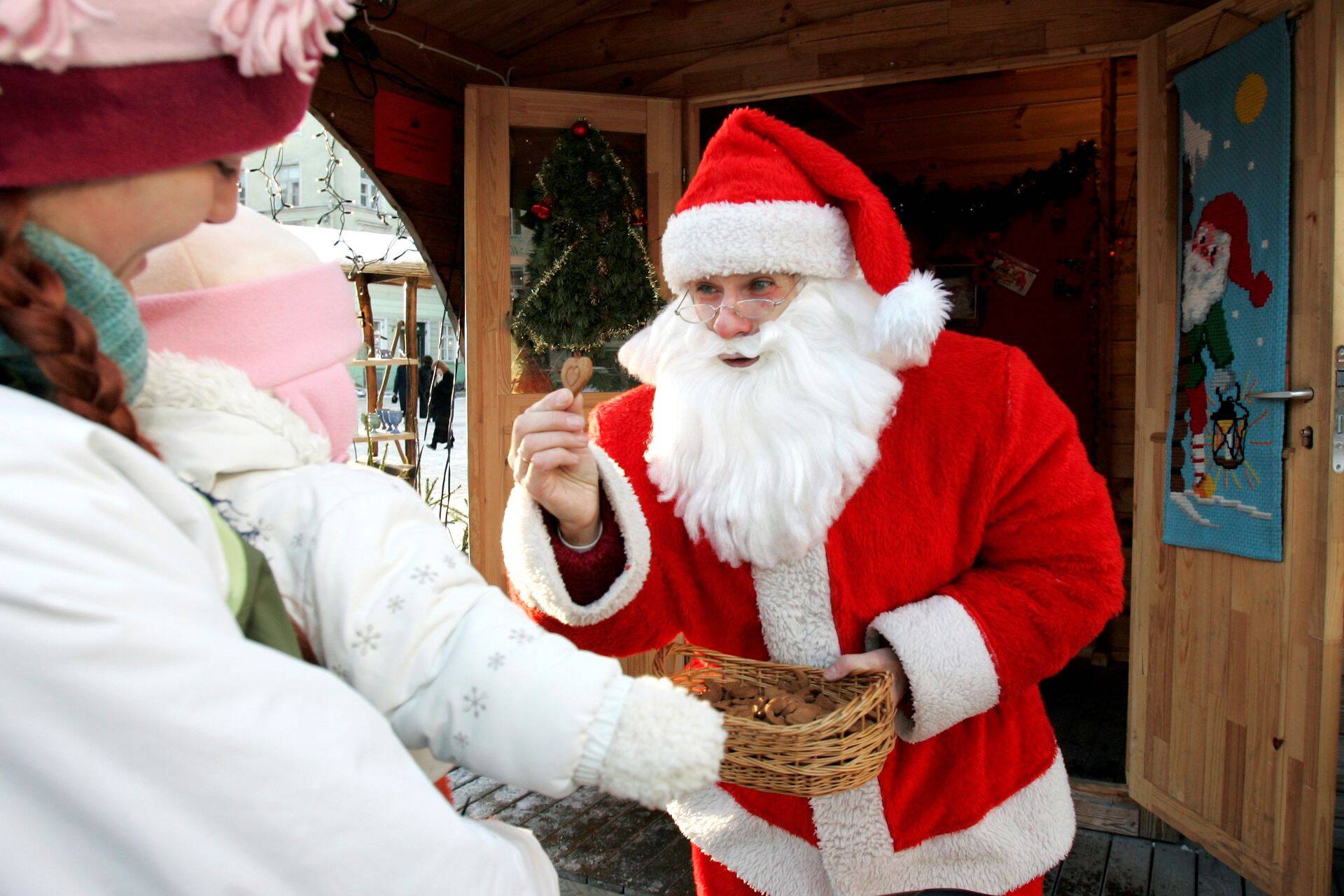 Jõuluvana annab lastele raekoja platsis piparkooke.