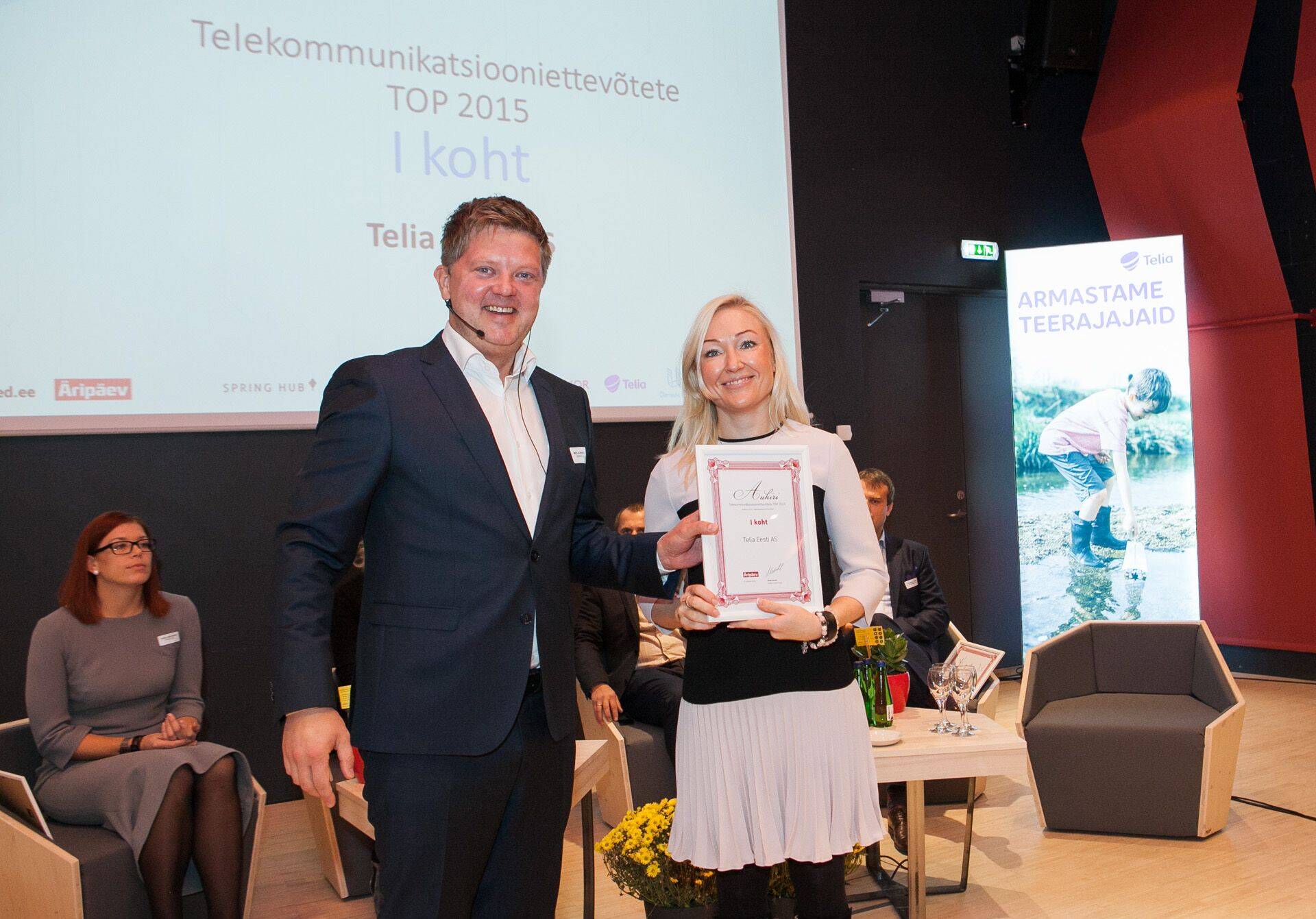 Telia Eesti tehnoloogiadirektor Kirke Saar IKT Aastakonverentsil võtmas vastu TOPI võitja aukirja Äripäeva peatoimetajalt Meelis Mandelilt