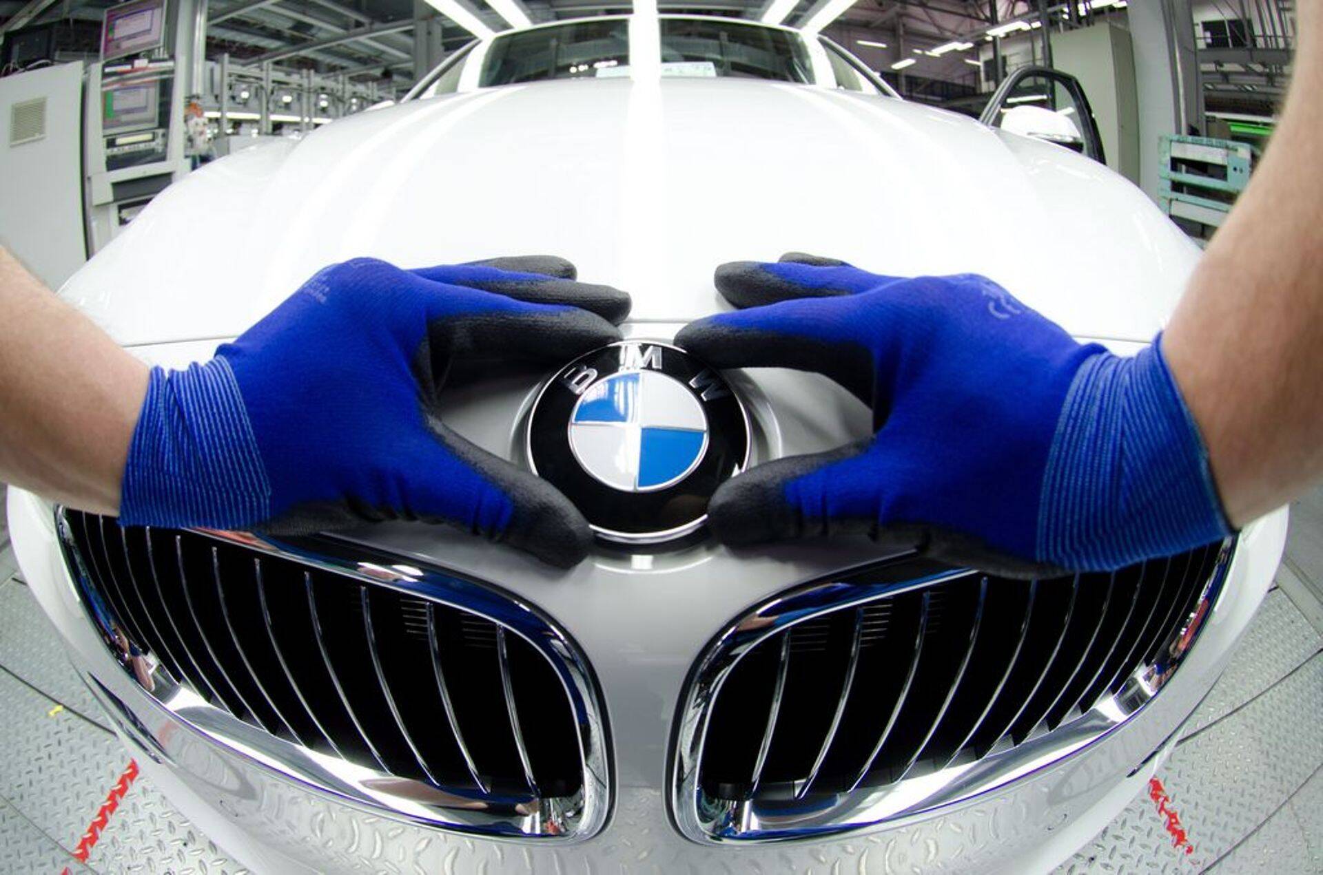 Töötaja paigaldab BMW tehases sõidukile logo.