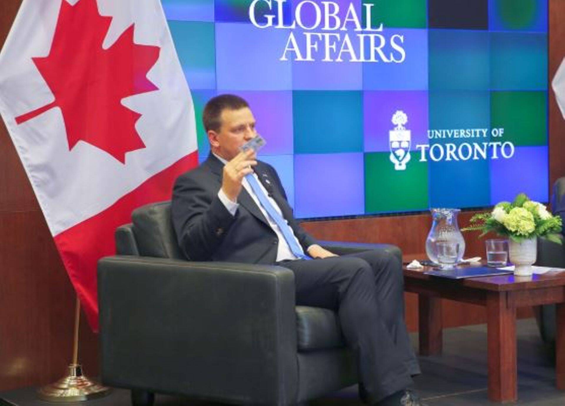 Jüri Ratas Kanadas Toronto Ülikoolis esinemas, käes Eesti ID-kaart.