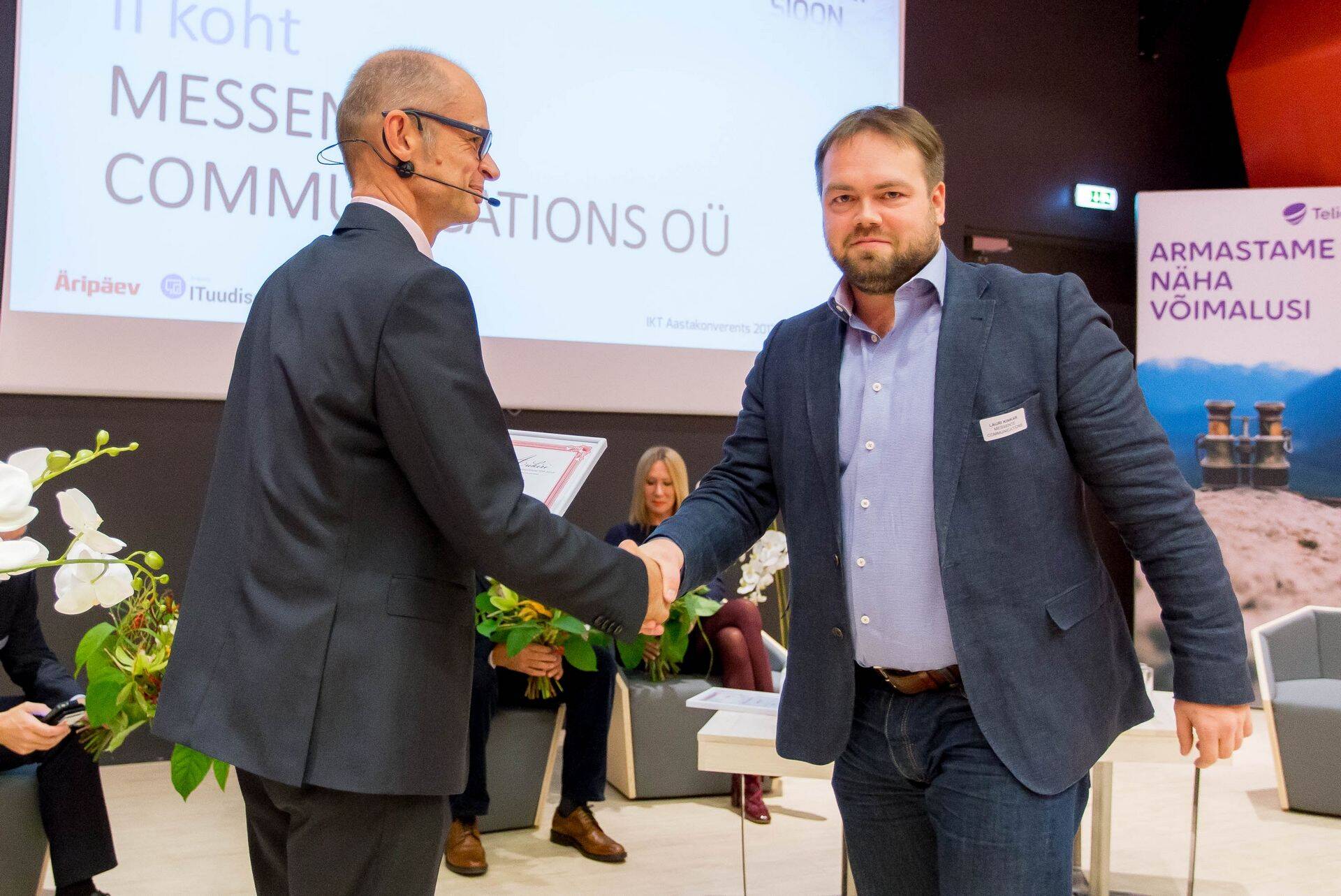 Lauri Kinkar IKT Aastakonverentsil vastu võtmas TOPi II koha aukirja Äripäeva peadirektorilt Igor Rõtovilt.