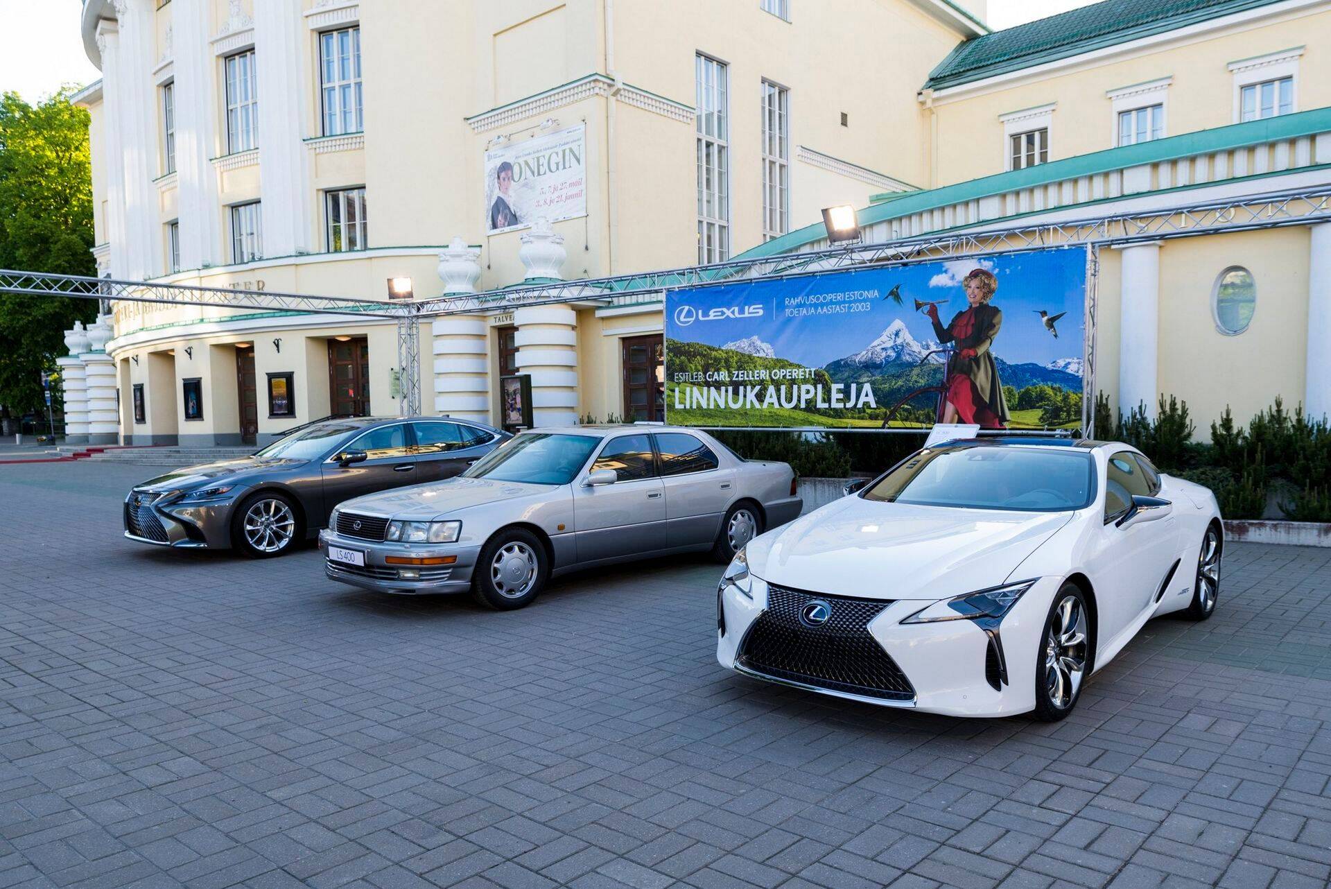 Презентация нового спортивного купе Lexus LC 500h с гибридной силовой установкой (крайний справа) и нового флагмана модельного ряда седана Lexus LS (крайний слева) неслучайно проходила перед театром «Эстония». Японский автопроизводитель Lexus уже 14 лет является спонсором эстонской Национальной оперы, а потому давно заслужил право присутствовать на её территории. Производство топовой модели Lexus LS пятого поколения только что начато, поэтому представленный в Таллинне экземпляр является одним из первых, сошедших с заводского конвейера. Для того, чтобы подчеркнуть достоинства новинки и продемонстрировать эволюцию своего главного автомобиля, японцы рядом с ним поставили модель LS первого поколения 1989 года выпуска (в центре).