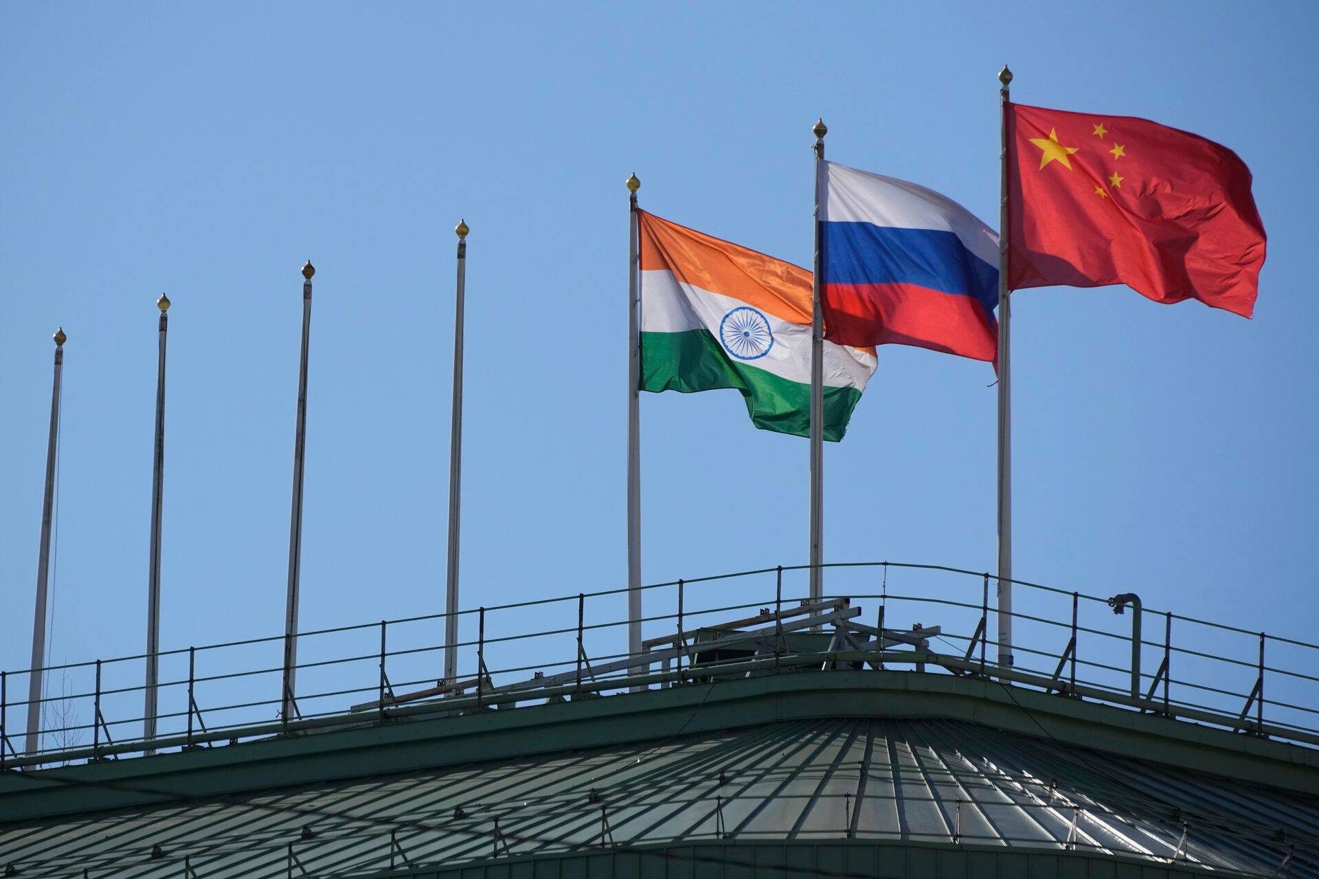 Флаги Индии, России и Китая развеваются на крыше отеля в центре Санкт-Петербурга, флаги других стран с нее сняли. Санкт-Петербург, Россия, 17 марта 2023 г.