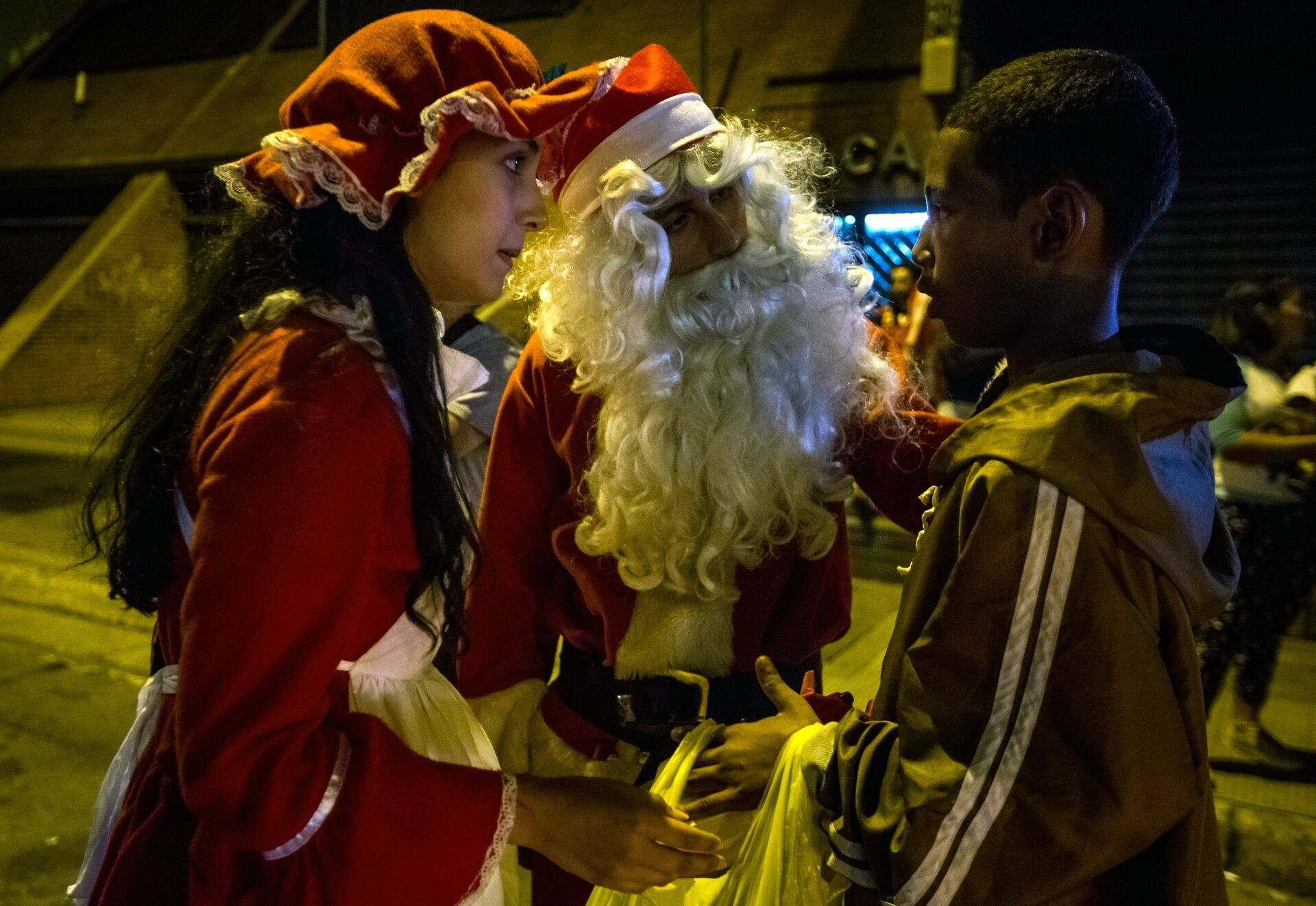 Venezuelas tegutsev Jõuluvana Ühing annab Caracase agulipoisile üle kingituse – toitu, vett ja riideid.