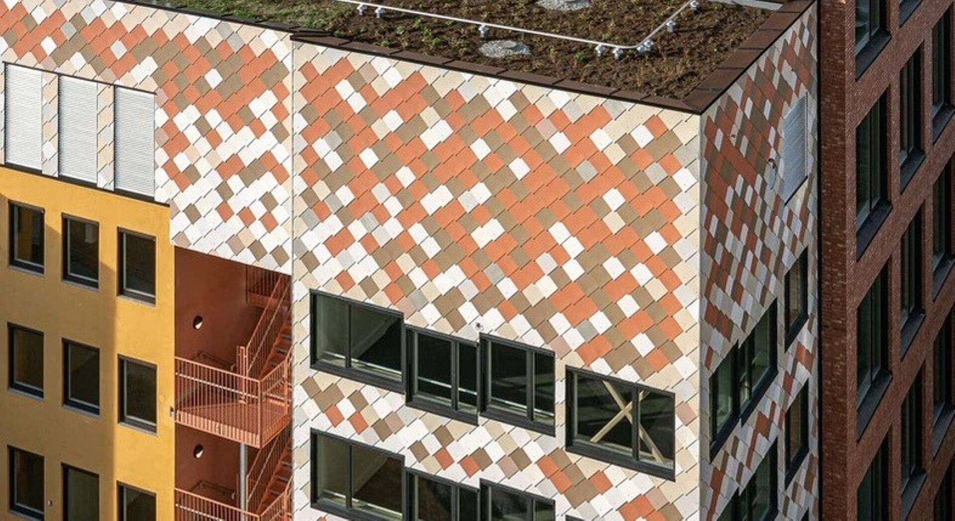 Taaskasutusmaterjalidest ehitatud 8-korruseline juurdeehitus Oslos. Hoone aknad hangiti näiteks teiselt ehitusobjektilt, millele need ei sobinud tootja eksimuse pärast. (Foto: Mad Arkitekter)