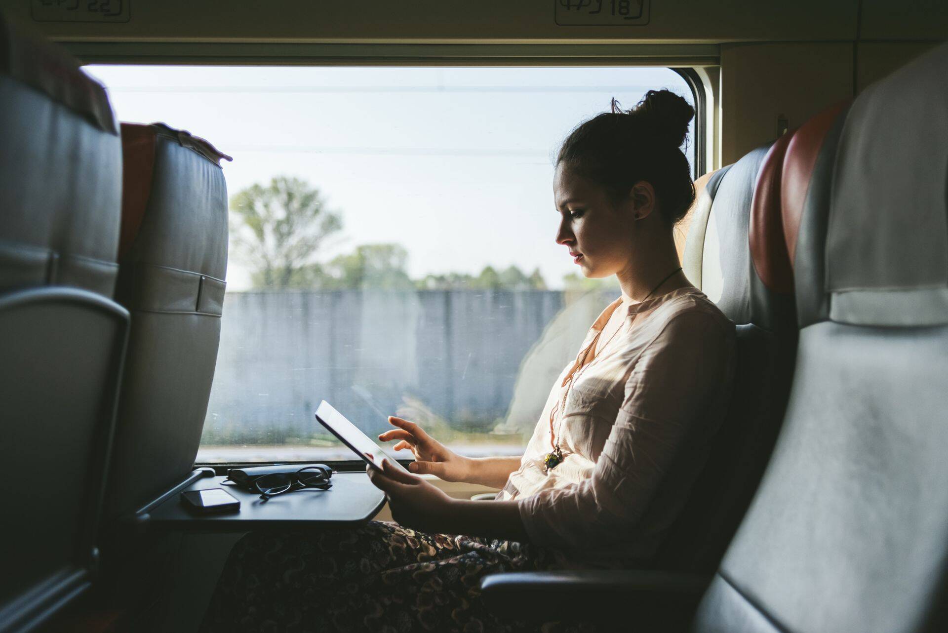 Woman using a tablet sitting in the train.