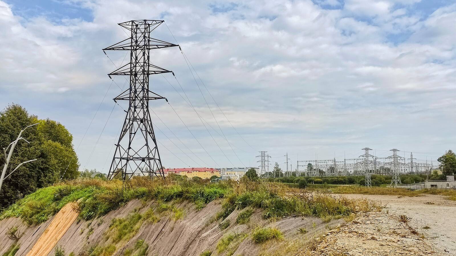 По состоянию на январь 2025 года передача энергии между двумя странами еще при необходимости происходит. Но кое-где отключение от российской электросети произвели физически. На заднем плане подстанция ГЭС в Ивангороде, на переднем – опора ЛЭП в Нарве, с которой летом 2024 года сняли провода.