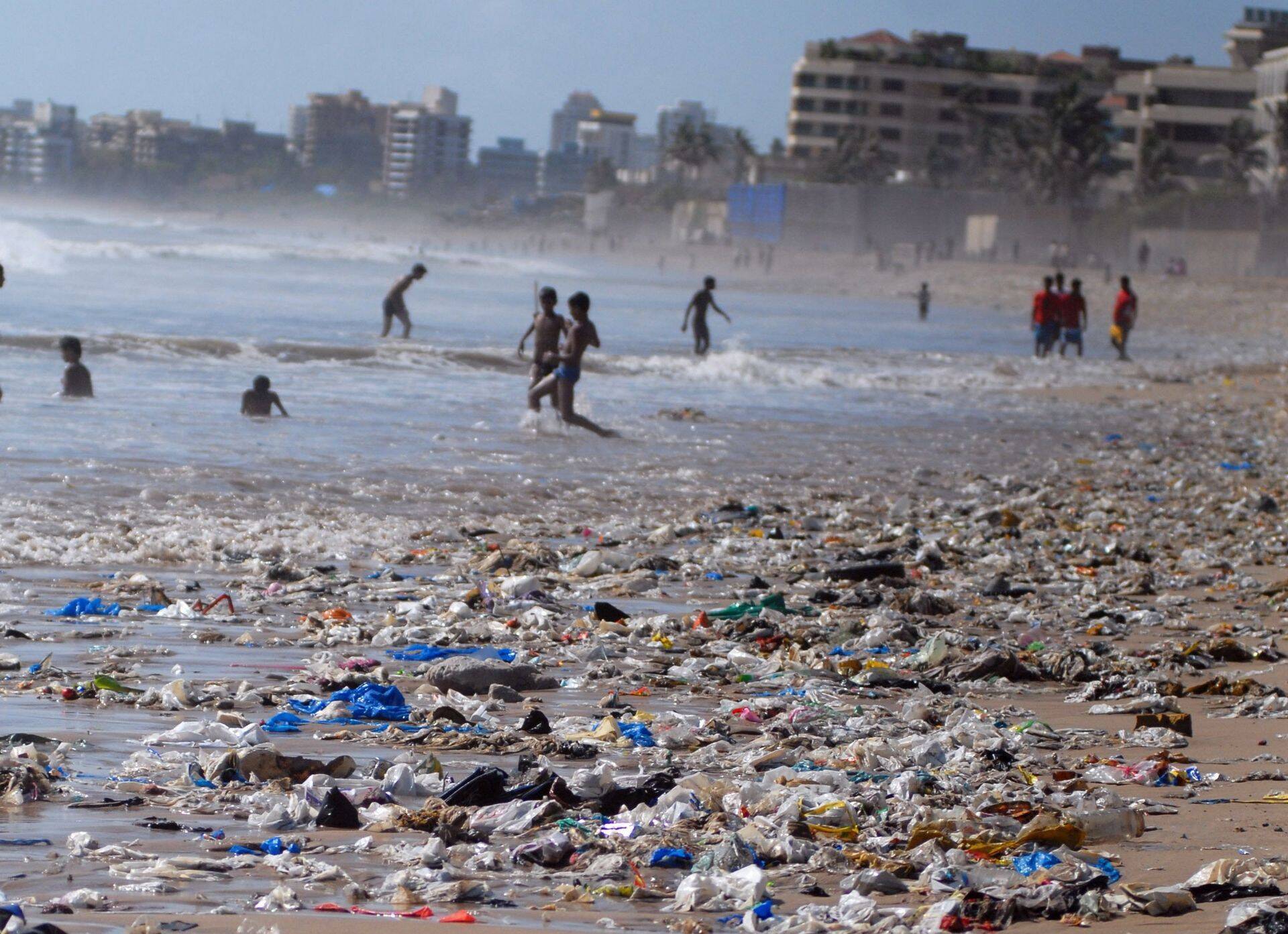 Inimesed suplevad Indias Mumbais rannas, mis on täis plastprügi.