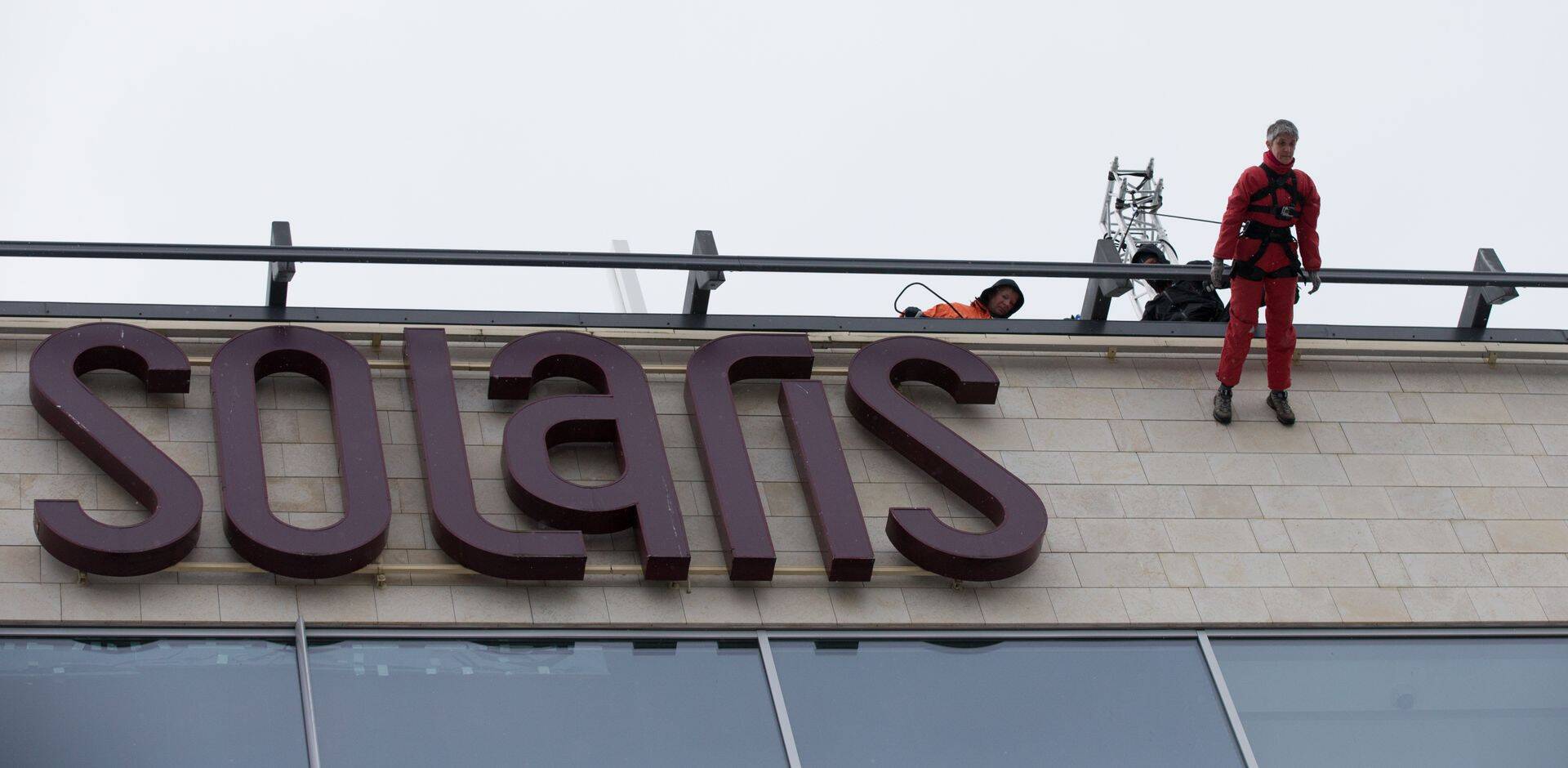 Eesti tantsija Mari Mägi kõnnib Solaris keskuse seina mööda alla.