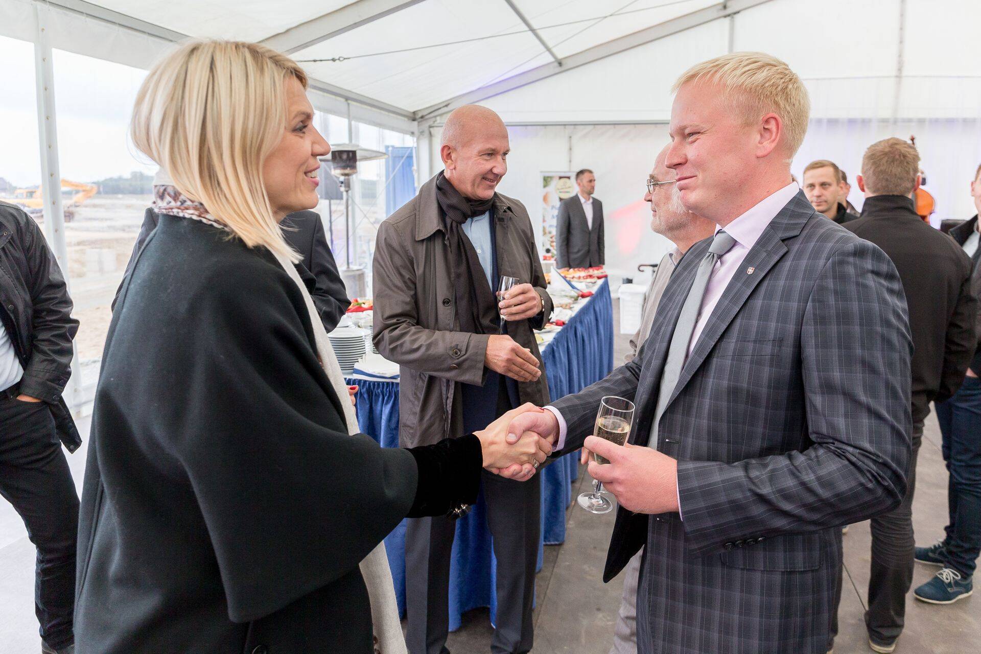 Rae vallavanem Mart Võrklaev surub Urve Palo kätt 2014. aastal Maxima logistikakeskuse nurgakivipeol.