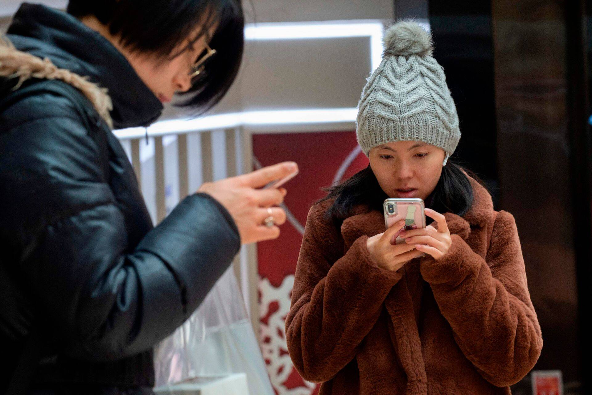Naine kasutab iPhone'i Pekingi kaubanduskeskuses.