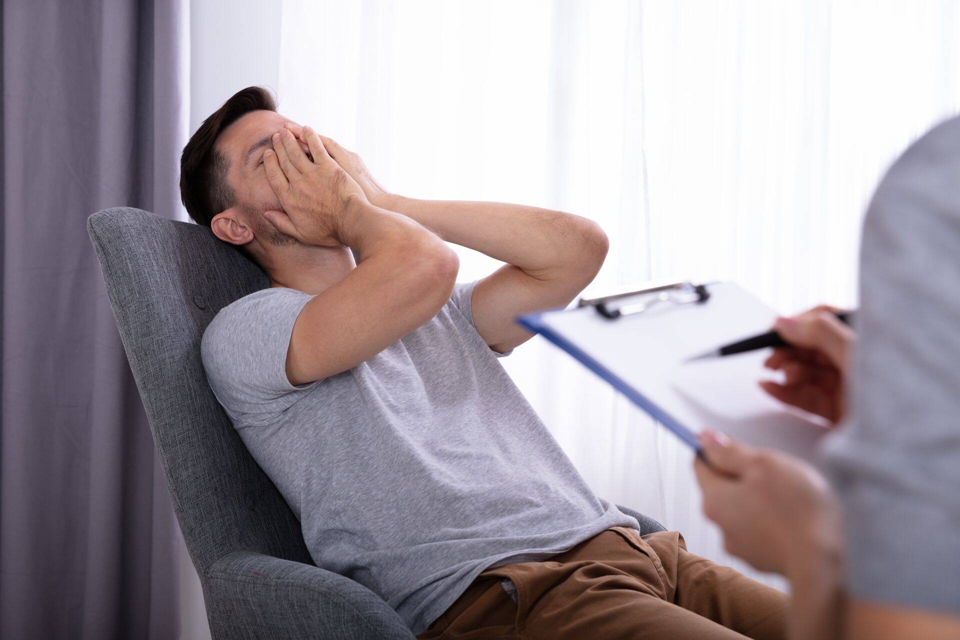 Psychologist Sitting Near Man Suffering From Depression