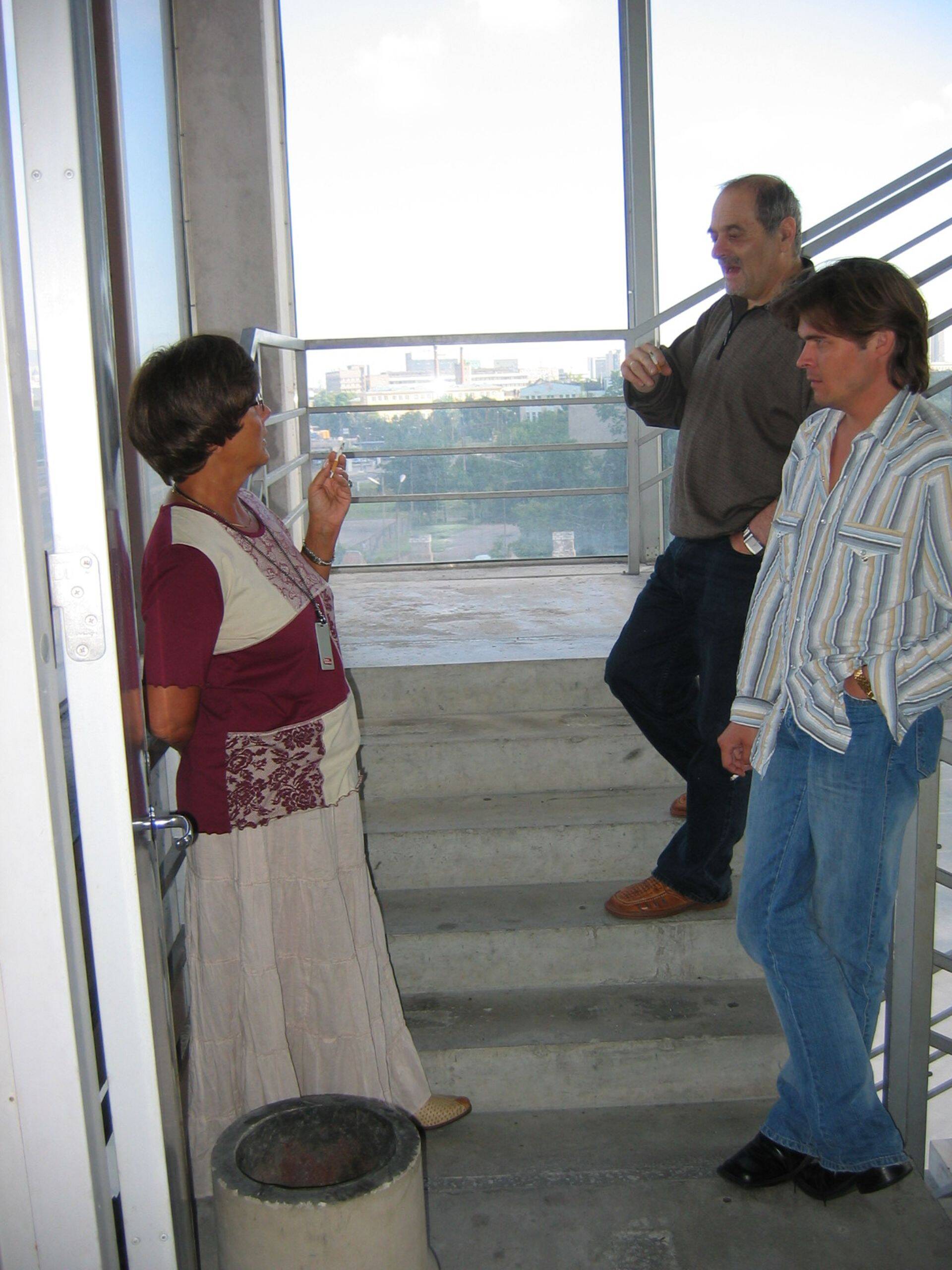 Курилка на аварийной лестнице пятого этажа здания Äripäev на Пярну мнт. - место, где рождались идеи для материалов и решались многие рабочие моменты. На фото: Вера Прохорова (слева), Эльконд Либман, Артур Тооман. Лето 2005.
