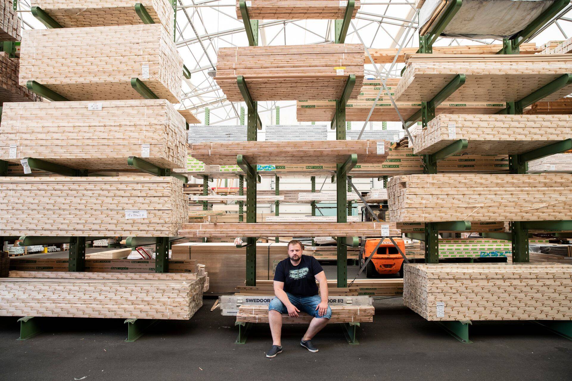 Puumarket Mustamäe osakonna juhataja Kauri Kasemägi istub laos, mis on erinevat puitu täis.