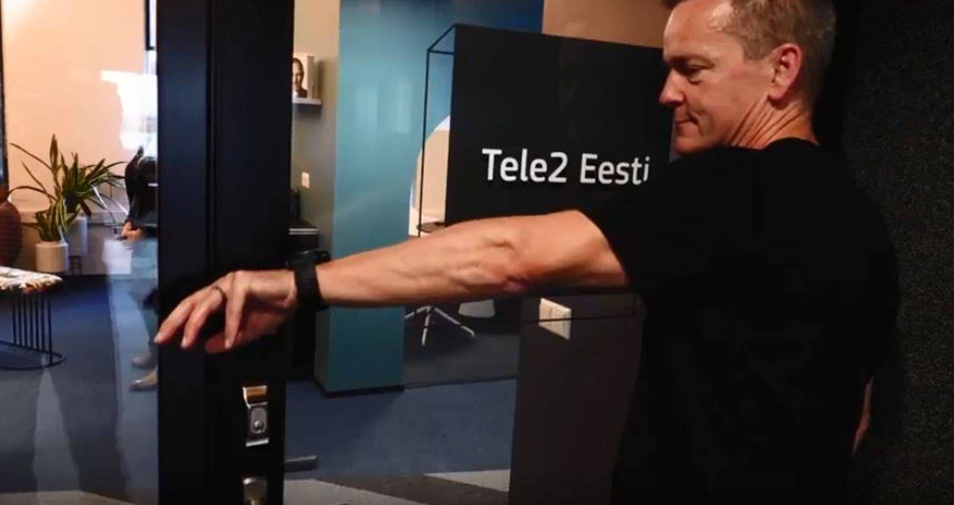 Tele2 Eesti juht Chris Robbins naha alla asetatud kiibiga esmakordselt kontori ust avamas.
