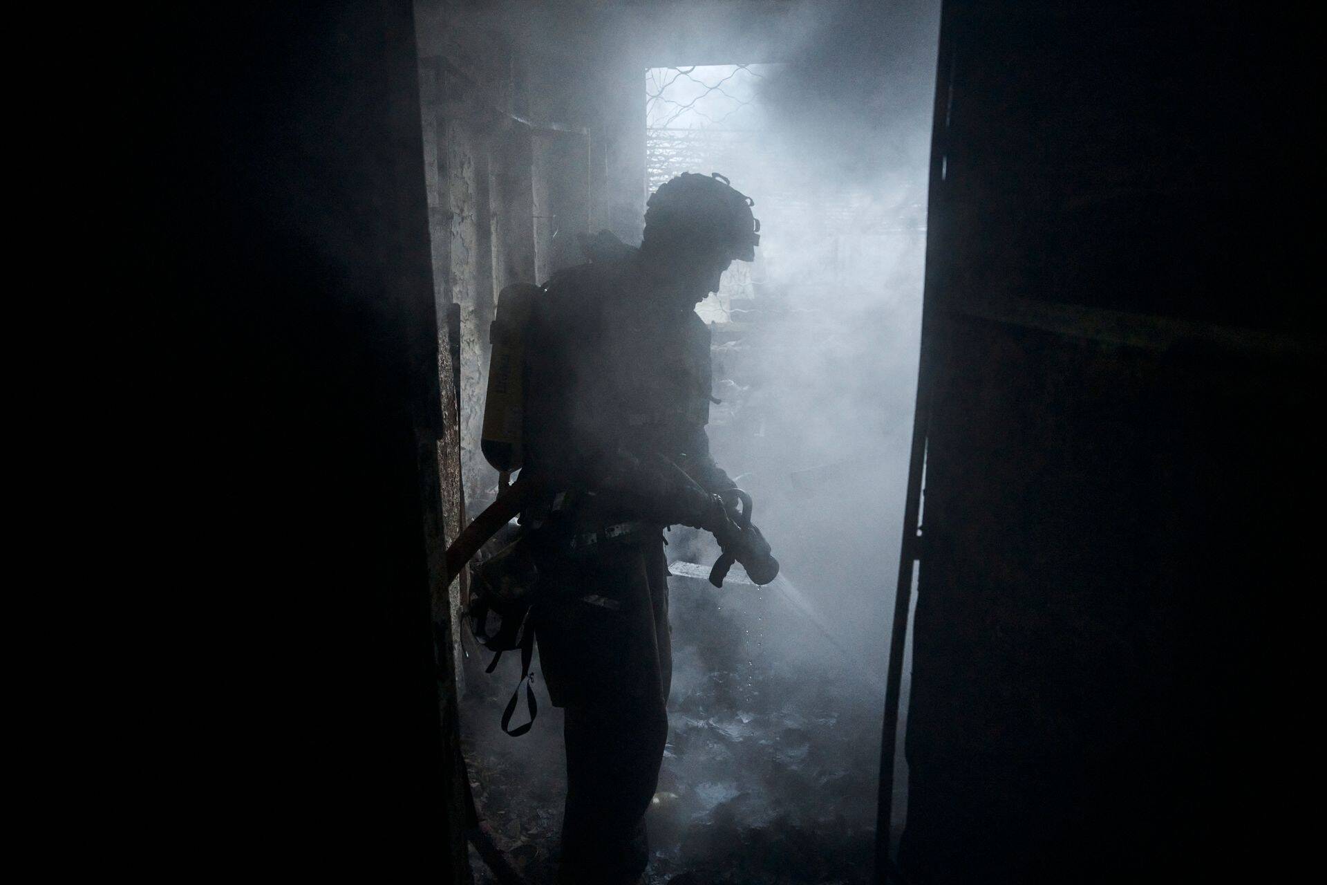 Спасатели тушат пожар на одном из предприятий Херсона после российского обстрела.