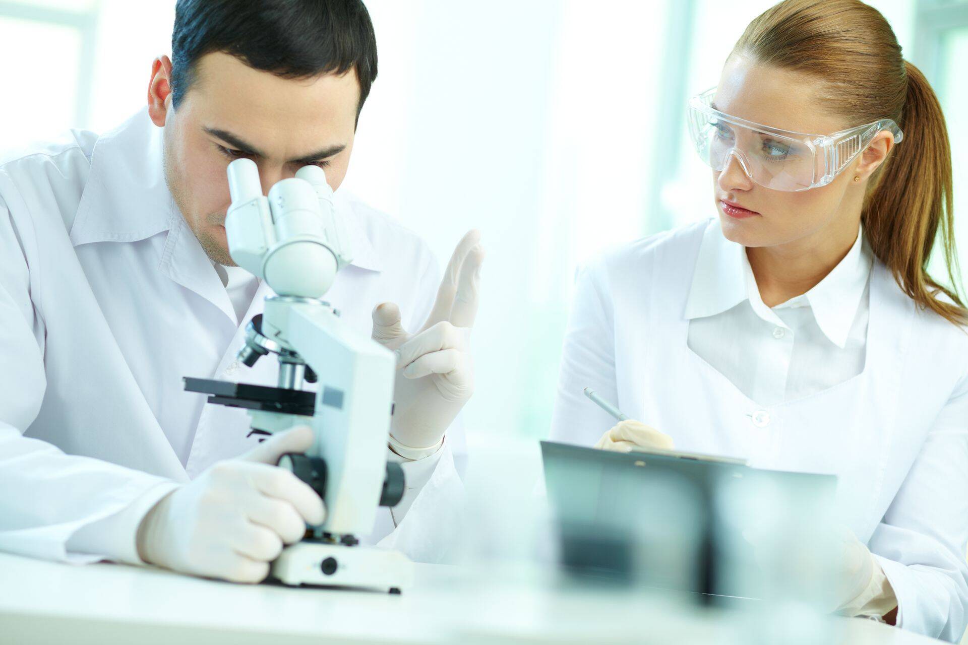 Serious clinicians studying chemical elements in laboratory
