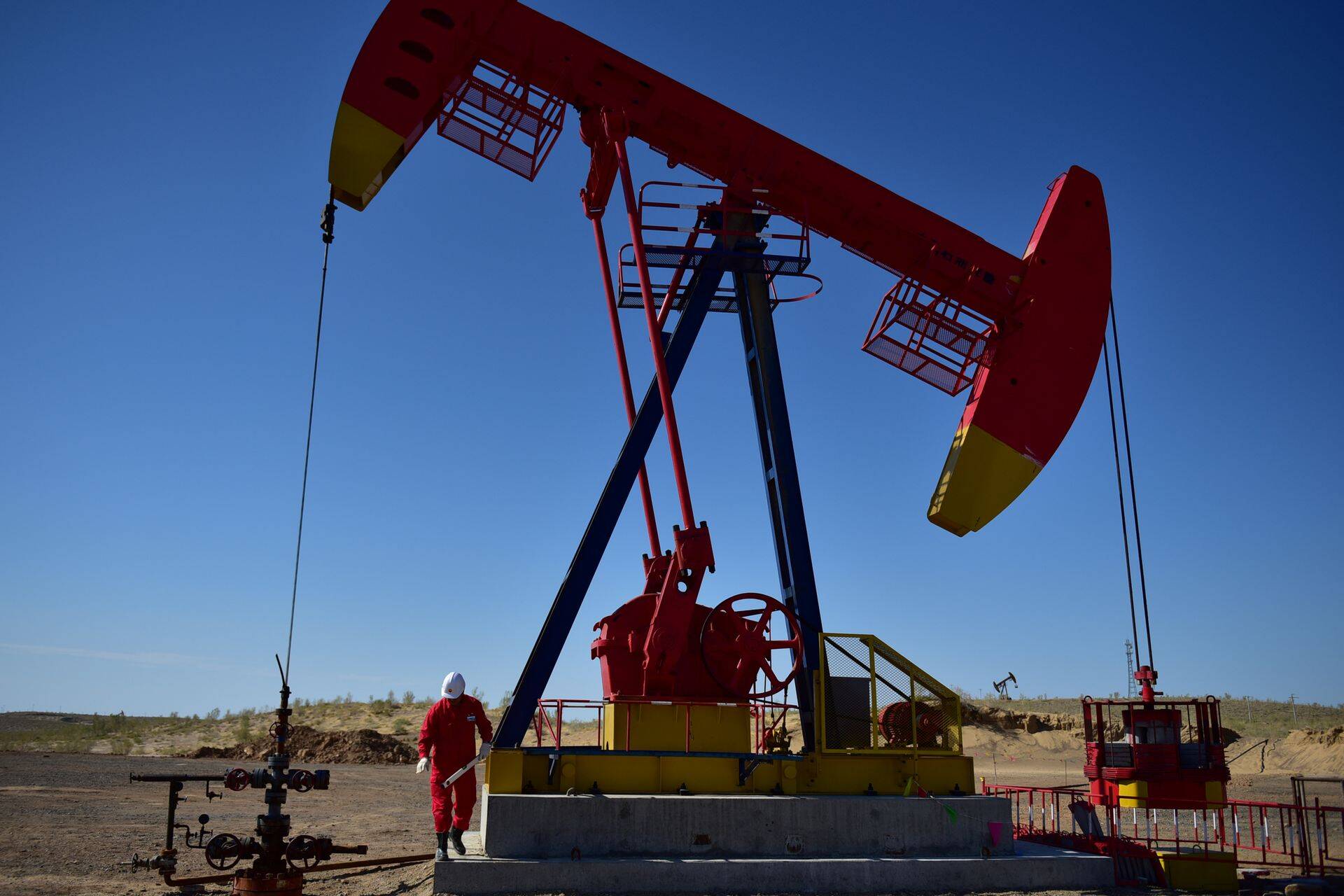 A worker inspects a pump jack at an oil field in Tacheng, Xinjiang Uighur Autonomous Region, China June 27, 2018. Picture taken June 27, 2018. REUTERS/Stringer ATTENTION EDITORS - THIS IMAGE WAS PROVIDED BY A THIRD PARTY. CHINA OUT.