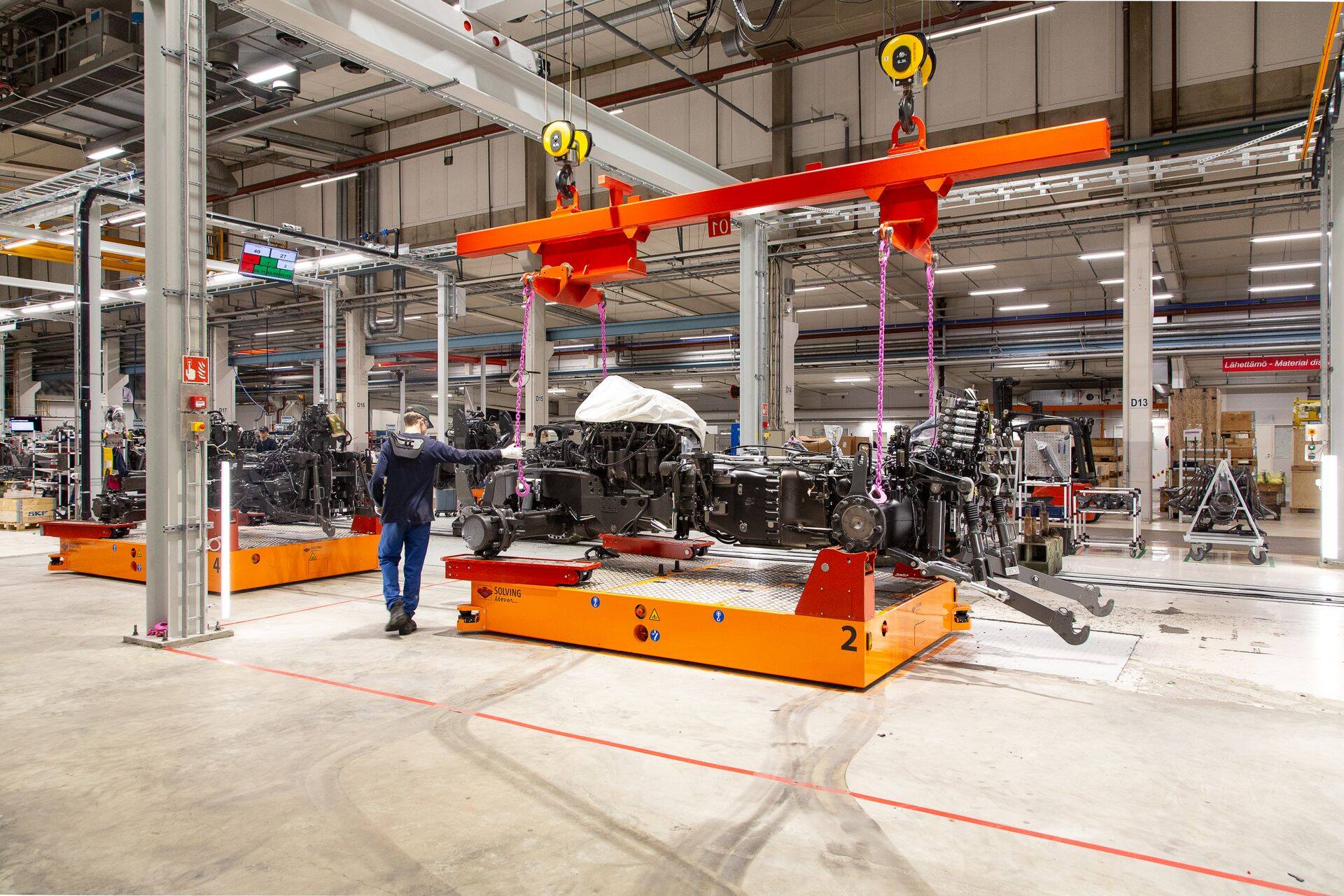 Traktoriraamid liiguvad värvitöökotta AGV-kärude abil.