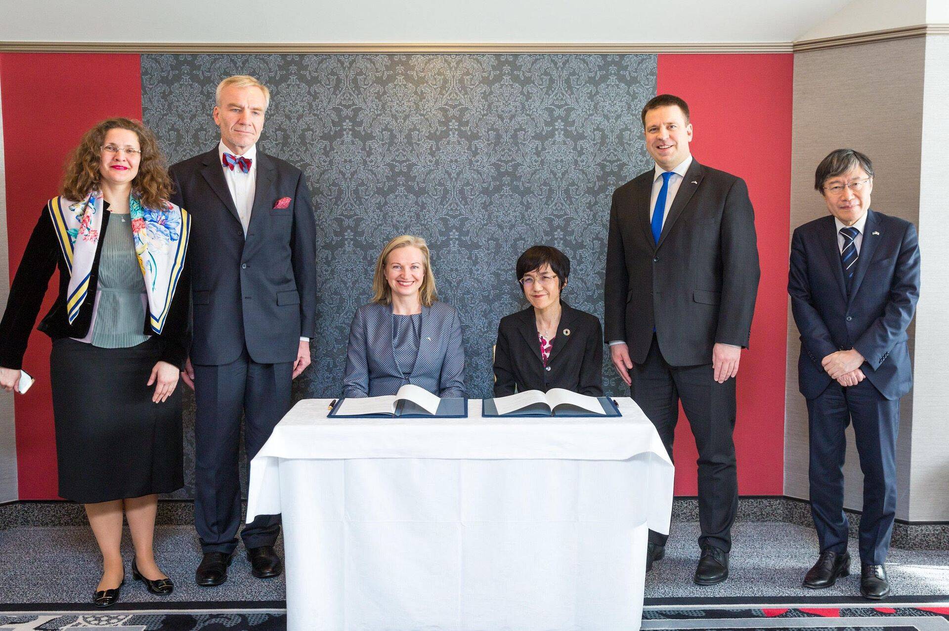 Lepingut allkirjastavad Helmese partner Kristi Pool ja Shionogi asepresident Takuko Sawada. Lisaks on pildil Helmese Euroopa Liidu suuna juht Kadri Sirg, Eesti suursaadik Jaapanis Väino Reinart, peaminister Jüri Ratas ja Jaapani suursaadik Eestis Hajime Kitaoka.